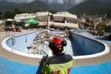 Un elemento de bomberos labora en la zona de un edificio derrumbado tras los terremotos en La Guaira, Venezuela.