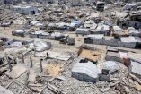 Se observan tiendas de campaña y refugios junto a los escombros de edificios derrumbados en un campamento para desplazados por la guerra, en el barrio de Sheikh Radwan de la ciudad de Gaza.