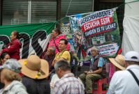 Trabajadores del IMSS en plantón descansan junto a una lona que busca integrar a los derechohabientes en la exigencia de condiciones dignas.