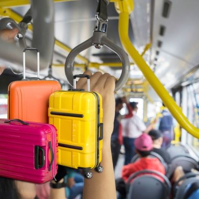 Maletas de viaje dentro de una unidad de transporte público de CDMX con pasajeros a bordo.