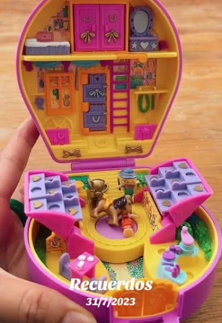 Estuche clásico de Polly Pocket rosa y amarillo, abierto con habitaciones, escaleras, pequeñas figuras y accesorios en miniatura.