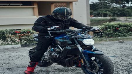 Persona sentada en su motocicleta volteando a ver el manubrio