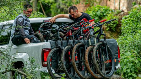 Dos personas subiendo varias bicis a una camino neta