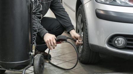 Persona checando el aire de una llanta de carro
