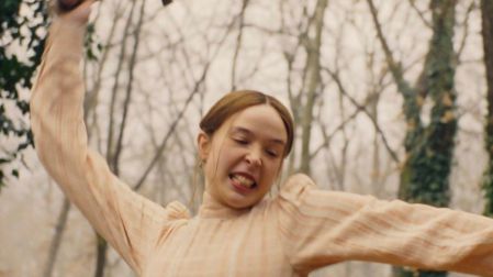 Escena de Monstruo La historia de Lizzie Borden con una mujer levantando un hacha en un bosque.