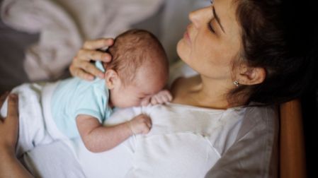 Mujer en posparto con bebé en brazos