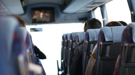 Pasajeros sentados en el interior de un autobús de pasajeros, alternativa de transporte ante una identificación vencida durante un viaje.