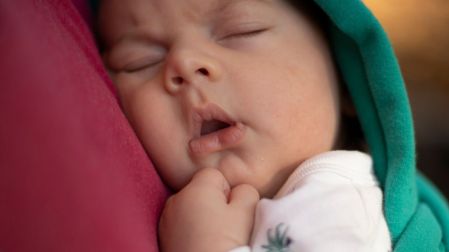 Bebé durmiendo en un portabebés.