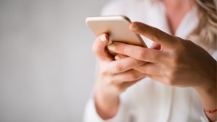 Mujer utiliza un celular para revisar y liberar espacio de almacenamiento ocupado por archivos de la categoría Otros.