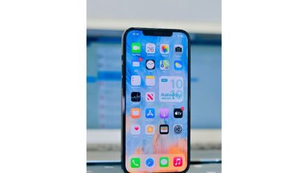 iPhone encendido frente a una computadora para gestionar el almacenamiento y reducir los Datos del sistema.