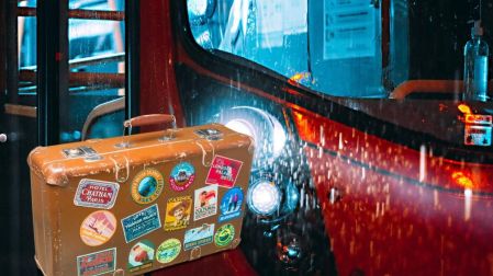 Maleta de viaje junto a una unidad de transporte público, relacionada con las reglas de equipaje en el Metrobús CDMX.
