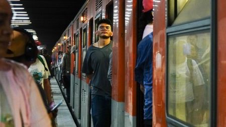 Pasajeros suben a un tren del Metro de CDMX durante un periodo de alta afluencia en una estación.