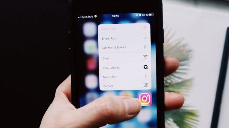 Persona mantiene presionado el icono de Instagram en la pantalla de un teléfono celular.