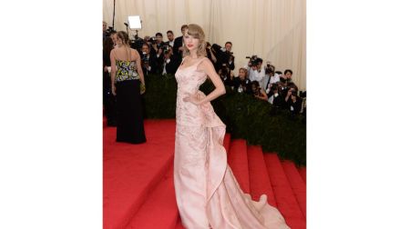 Taylor Swift apostó por un delicado vestido rosa de Oscar de la Renta con espalda descubierta y un espectacular lazo arquitectónico.