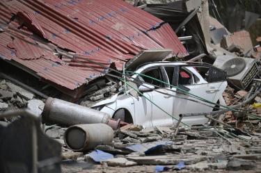 Un automóvil queda aplastado bajo los restos colapsados de un techo de chapa ondulada, entre los escombros, tras un terremoto en Catia La Mar, estado de La Guaira, a unos 30 km al noroeste de Caracas.