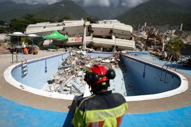 Un elemento de bomberos labora en la zona de un edificio derrumbado tras los terremotos en La Guaira, Venezuela.