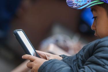 Un niño utiliza un celular para entretenerse.