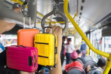 Maletas de viaje dentro de una unidad de transporte público de CDMX con pasajeros a bordo.