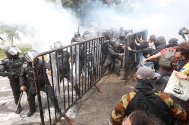 Elementos de seguridad en equipo táctico se enfrentan a los ciudadanos durante la manifestación que exigía agua limpia en Guadalajara.