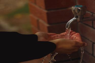 manos recolectando el agua que sale de una llave