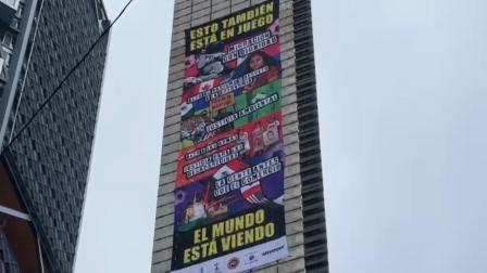 Greenpeace y Amnistía Internacional despliegan manta en la Estela de Luz