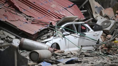 Un automóvil queda aplastado bajo los restos colapsados de un techo de chapa ondulada, entre los escombros, tras un terremoto en Catia La Mar, estado de La Guaira, a unos 30 km al noroeste de Caracas.