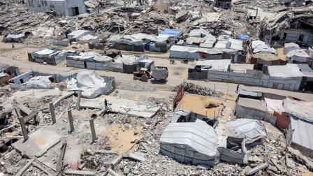 Se observan tiendas de campaña y refugios junto a los escombros de edificios derrumbados en un campamento para desplazados por la guerra, en el barrio de Sheikh Radwan de la ciudad de Gaza.